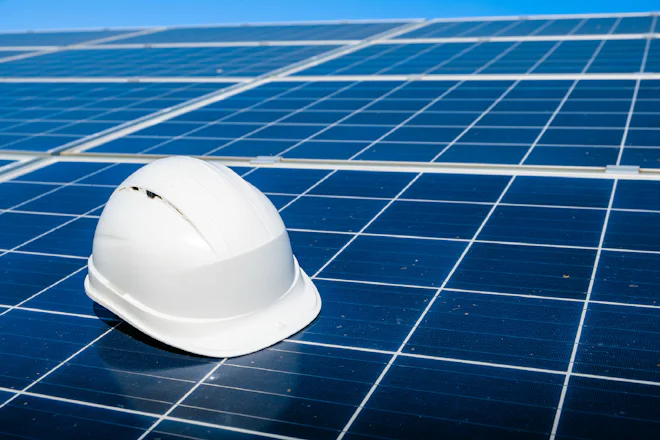 Capacete de segurança apoiado sobre módulos fotovoltaicos